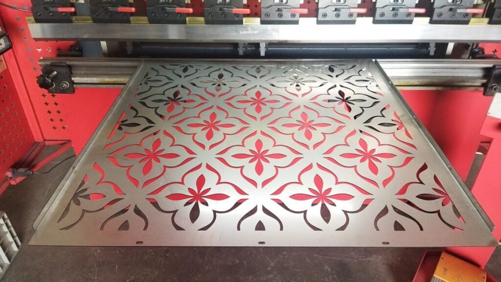 Painel cortado a laser sendo dobrado em máquina Dobradeira